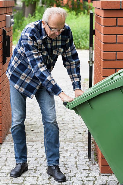 Elderly person with garbage bin